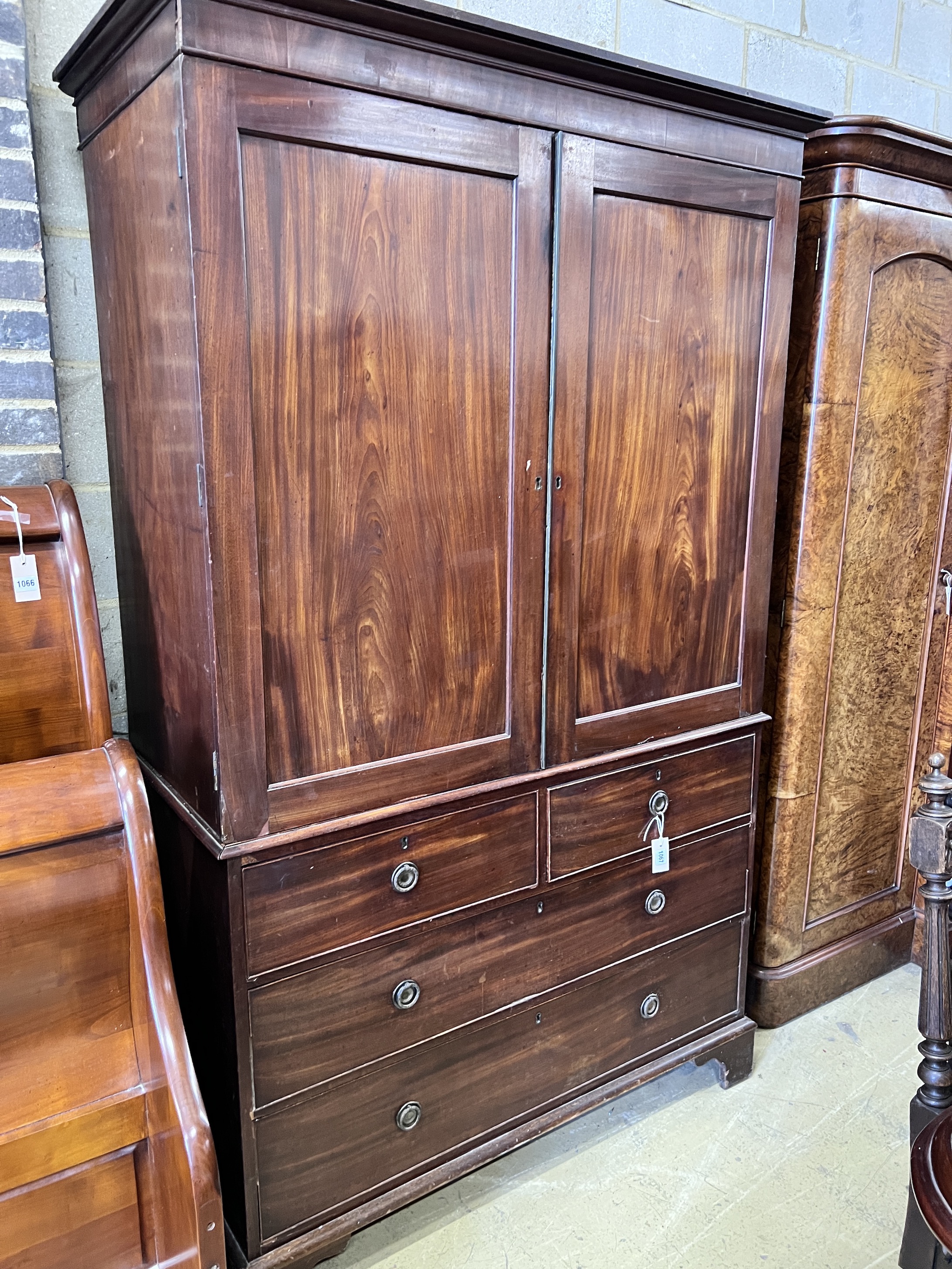 A George III mahogany linen press with two doors enclosing three adjustable shelves, width 125cm, height 205cm